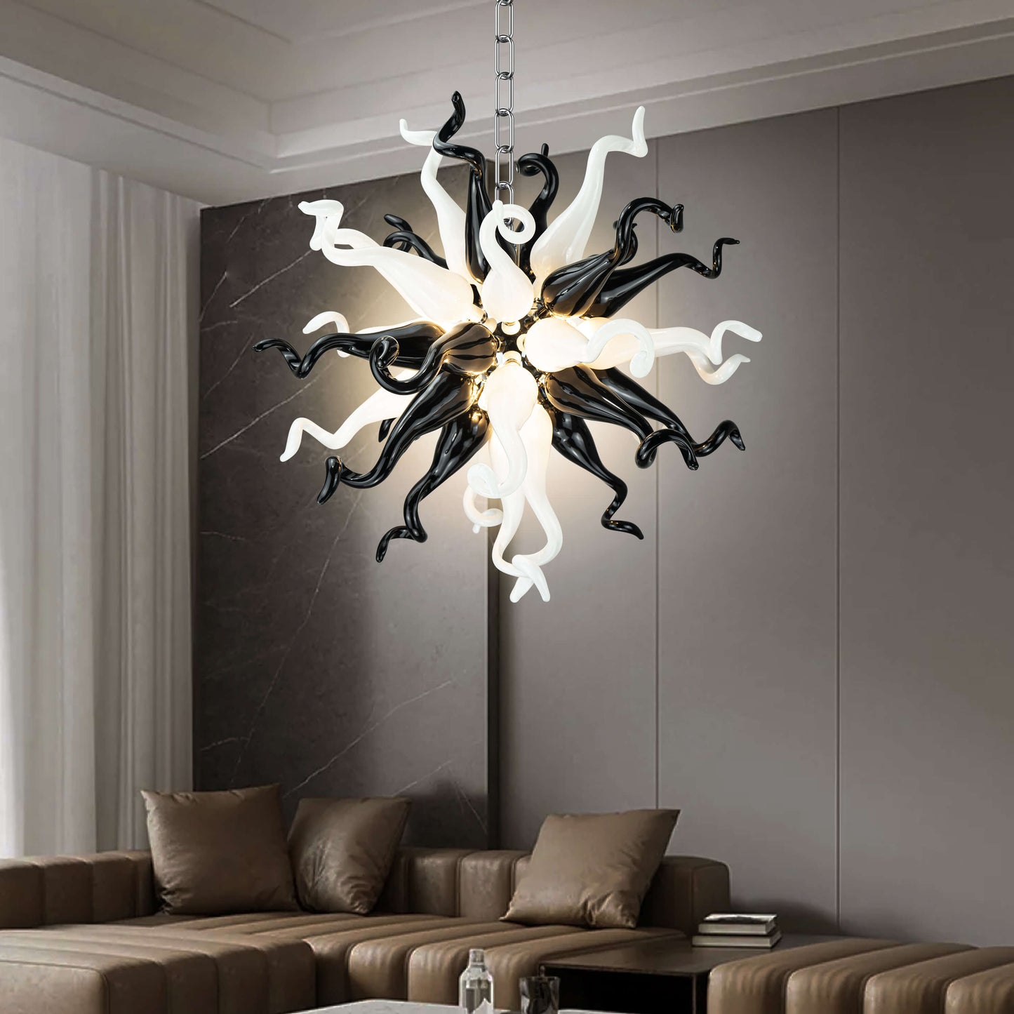 Modern Style Blown Glass Chandelier Black & White Burst hanging in a living room with a brown sofa and gray walls.