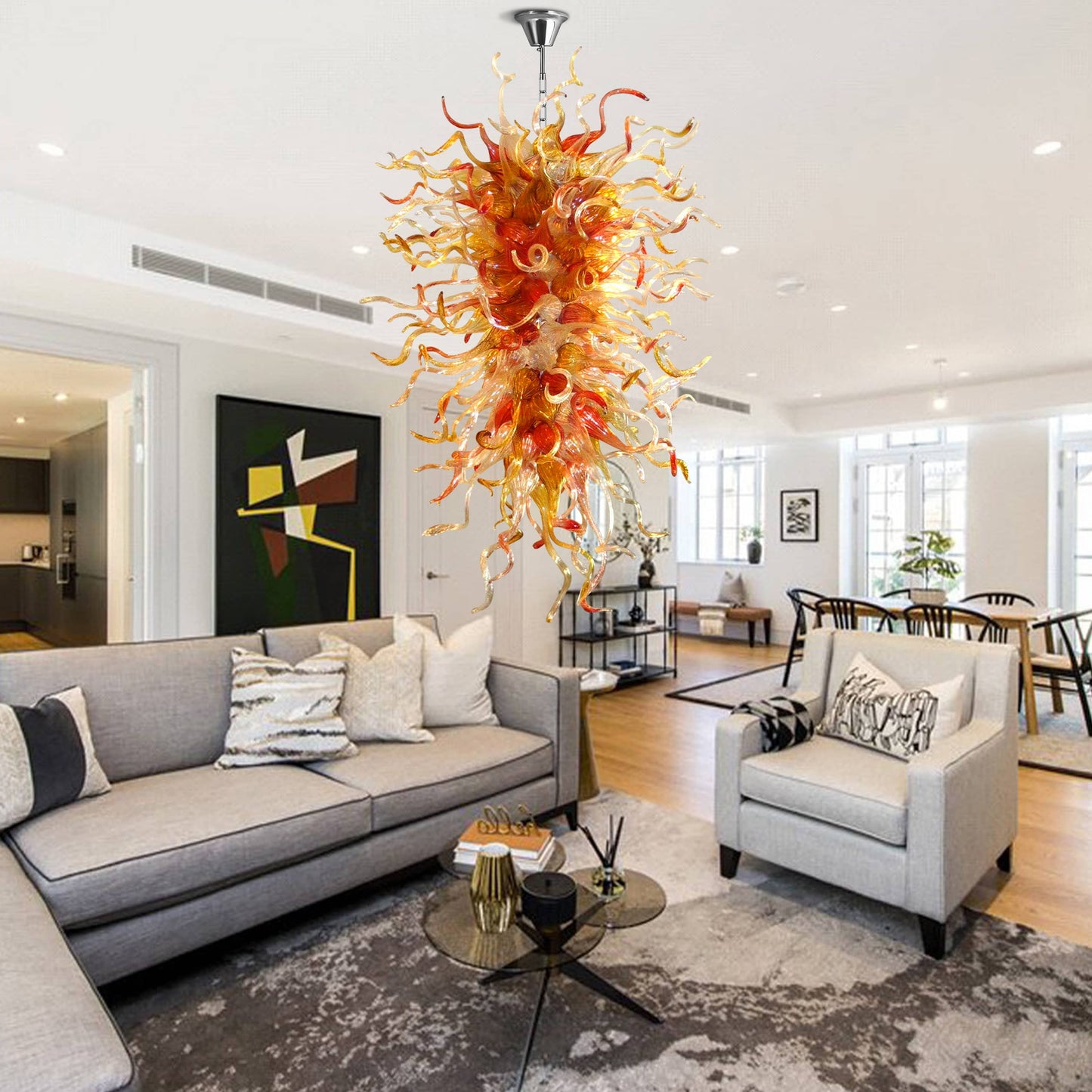 Artistic orange and red hand blown glass chandelier illuminating a stylish contemporary home interior.