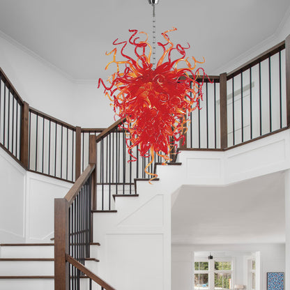 Artisanal hand blown glass chandelier with swirling tendrils in traditional stairwell.