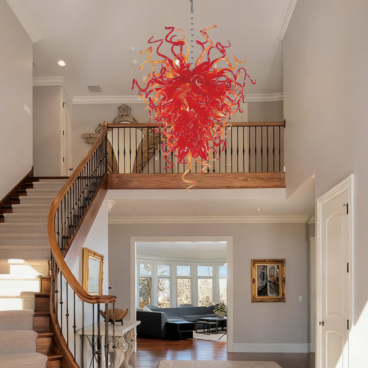 Artisanal red orange hand blown glass chandelier in transitional interior with artwork.