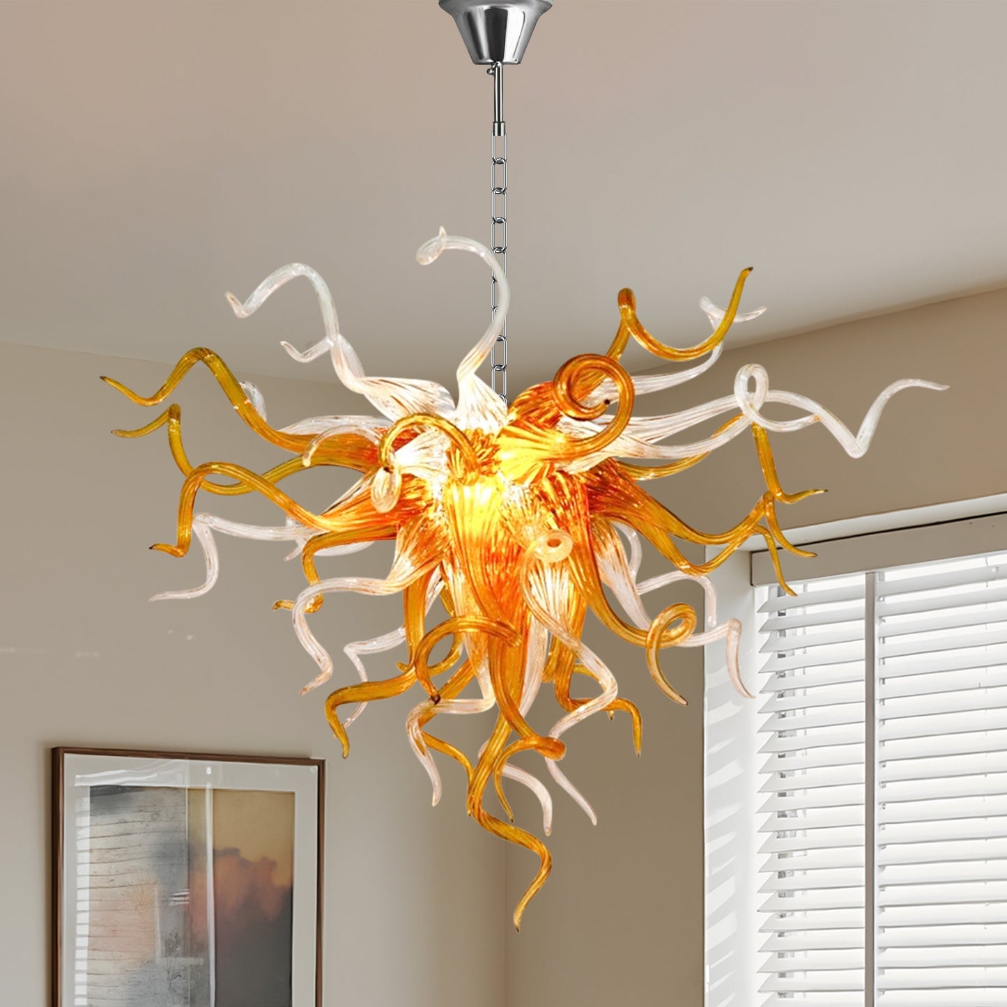 Chihuly-inspired amber and clear hand blown glass chandelier in room with white plantation shutters.