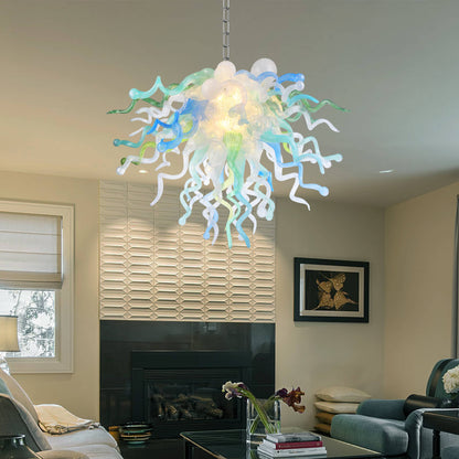 Modern colorful blown glass chandelier hanging in a living room with a fireplace and decor.