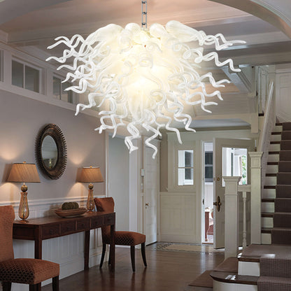 Modern living room decor highlighted by the radiant glow of a Chihuly-style pearl white blown glass chandelier.