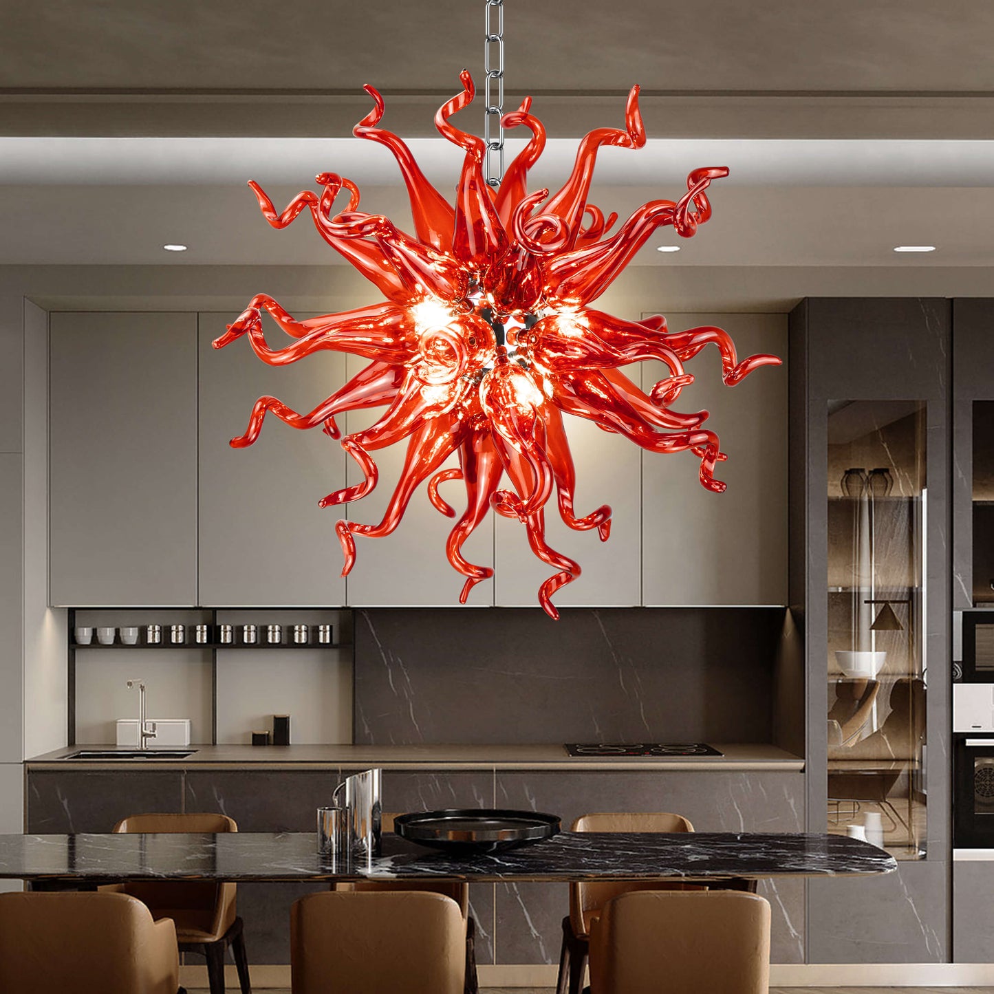 Red hand blown glass chandelier as a bold centerpiece above a modern kitchen island and living area.