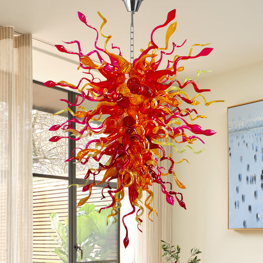 Vibrant hand blown glass chandelier with fiery red and orange colors hanging in a stylish dining area.