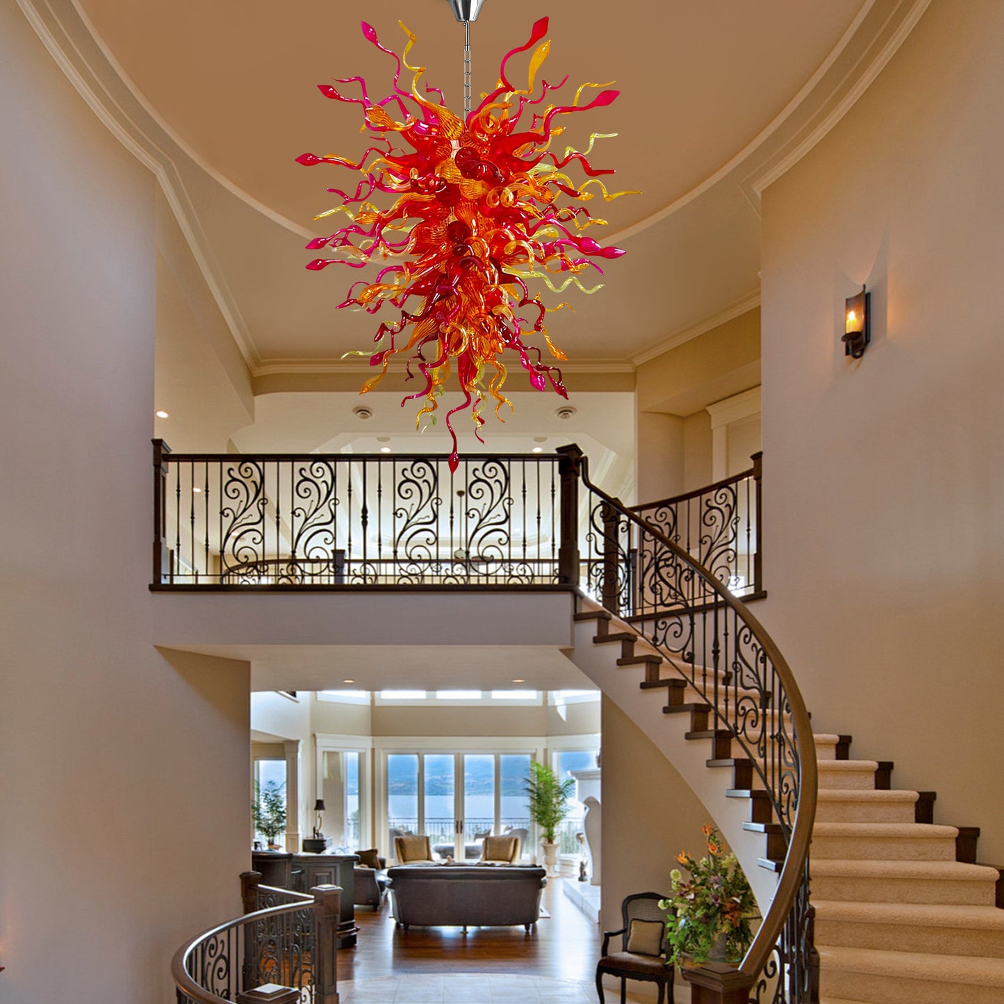 Elegant hand-blown glass chandelier as the centerpiece of a grand foyer with a curved staircase.
