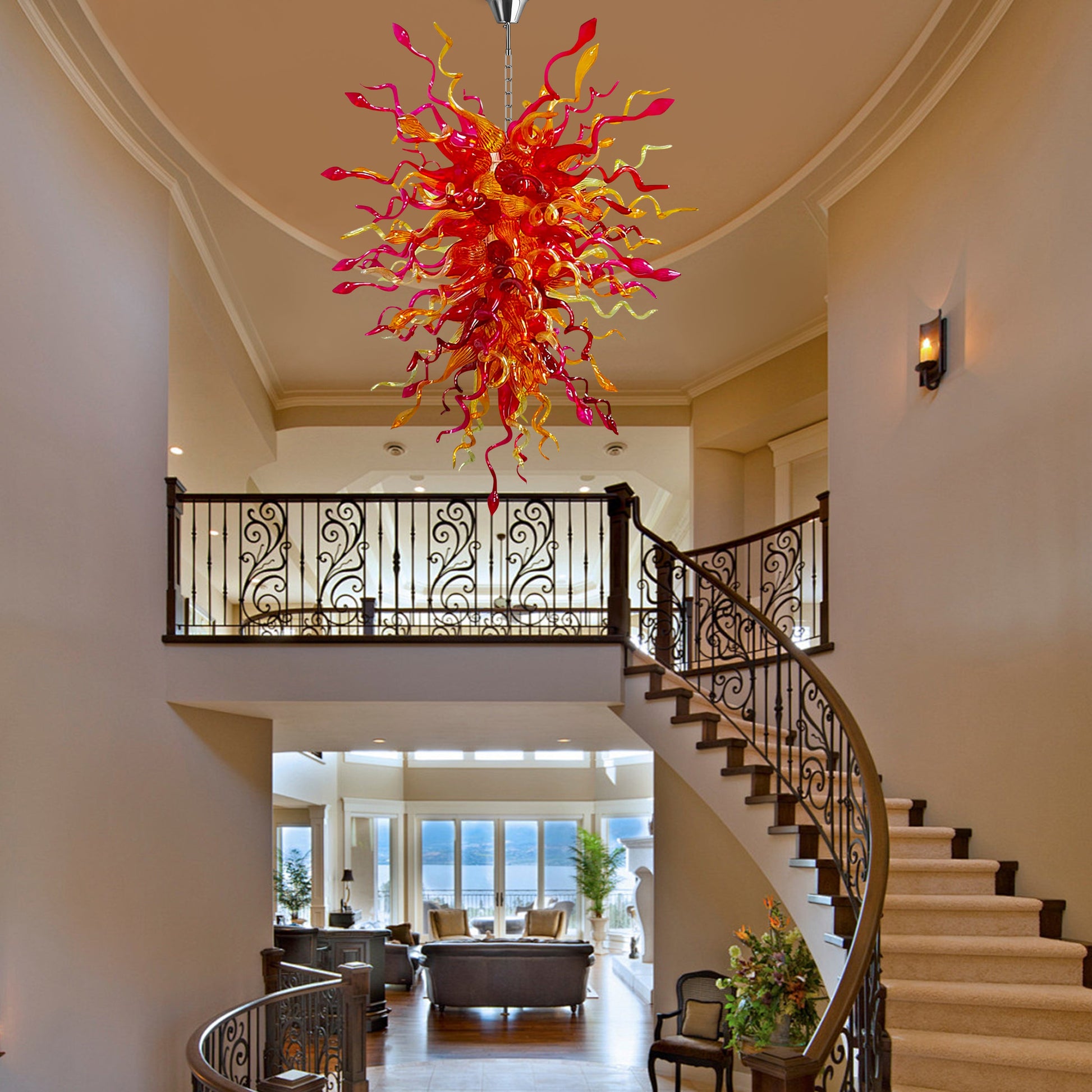 Elegant hand-blown glass chandelier as the centerpiece of a grand foyer with a curved staircase.