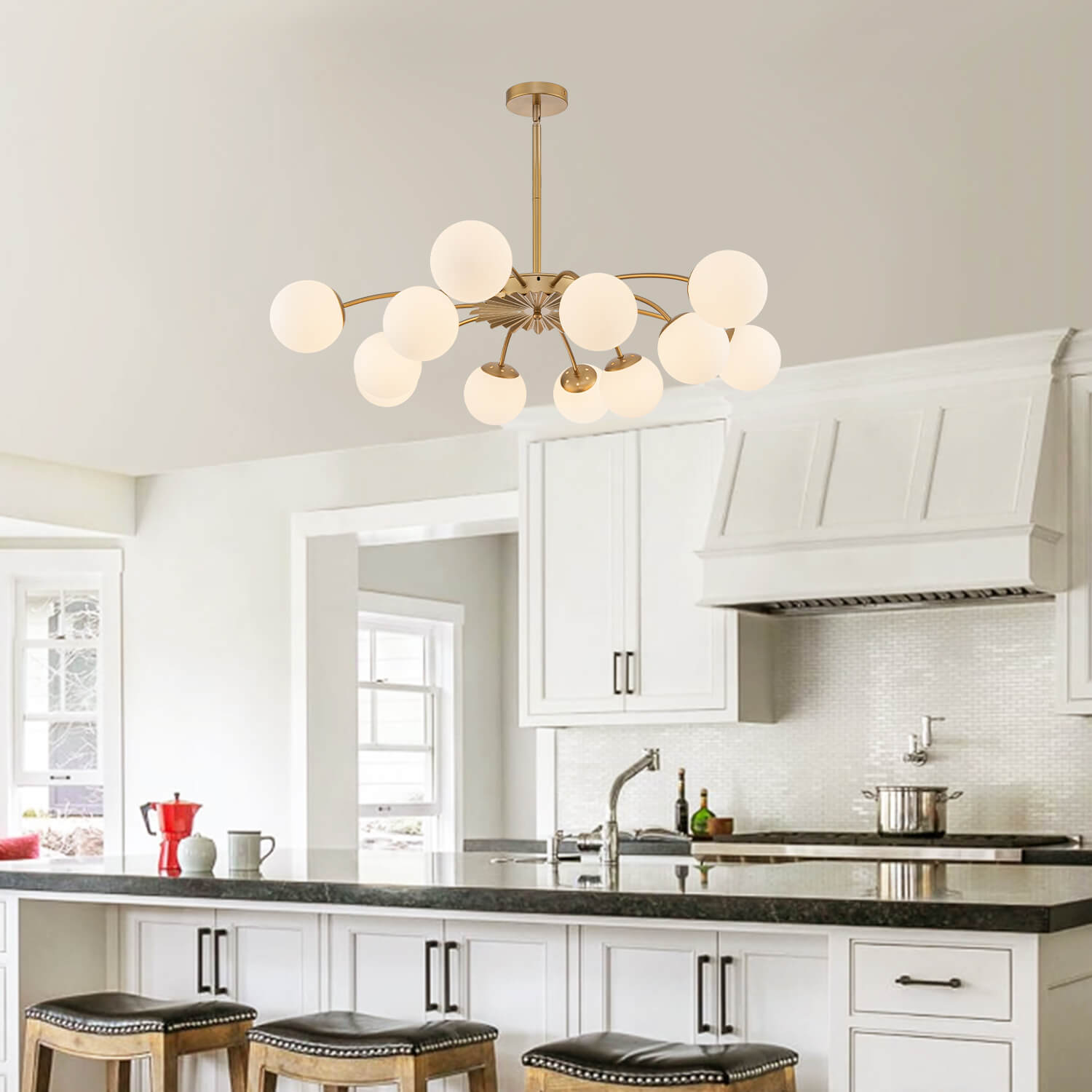 Adjustable gold 8-light frosted glass pendant bubble ball chandelier in white kitchen with black countertop.
