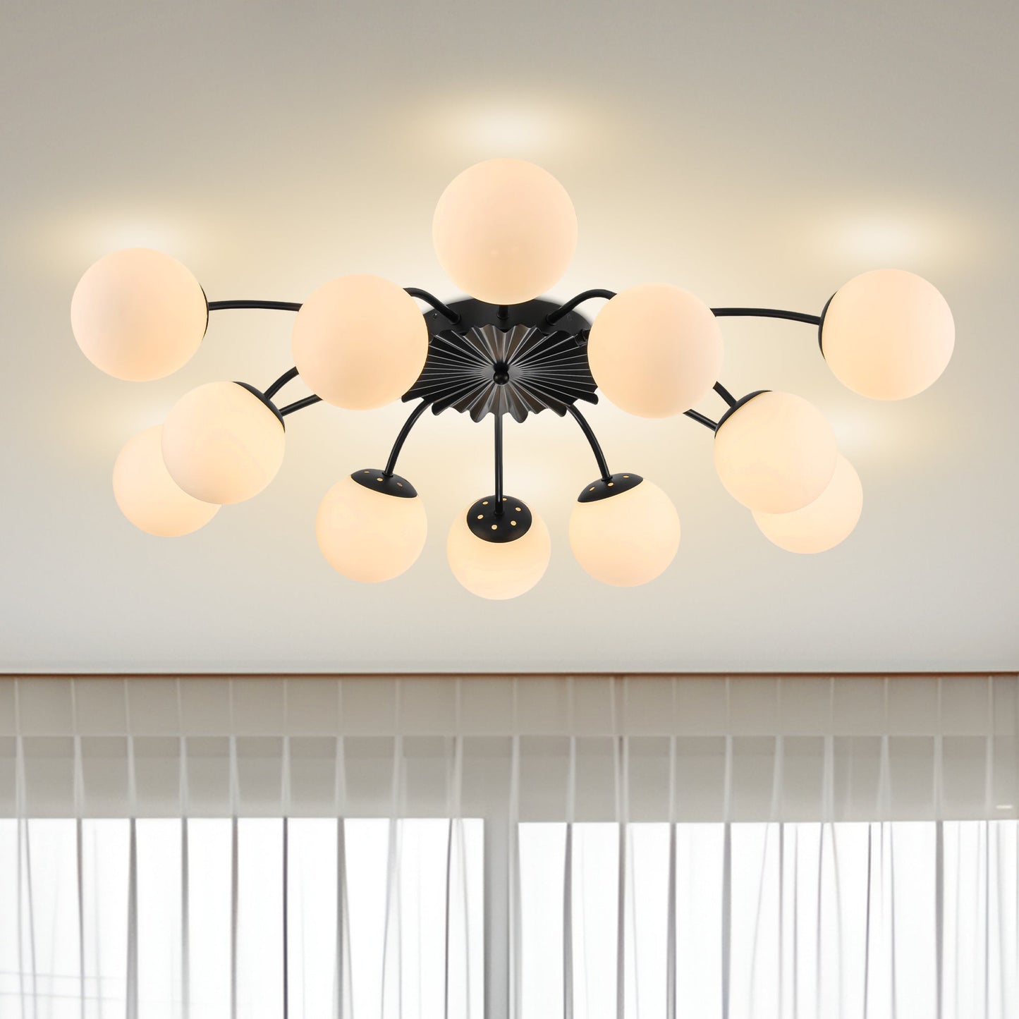 12-Light black ball semi-flush mount ceiling light in modern living room with clear curtains.