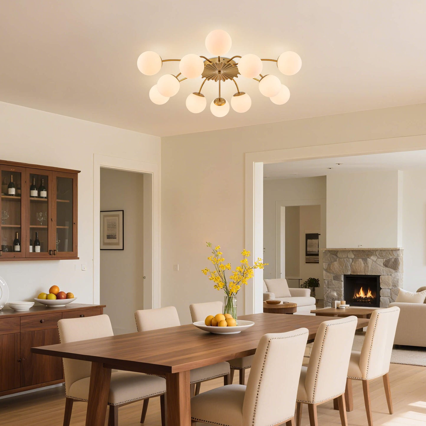 12-Light gold globe ceiling light in light-filled dining room with wooden furniture.