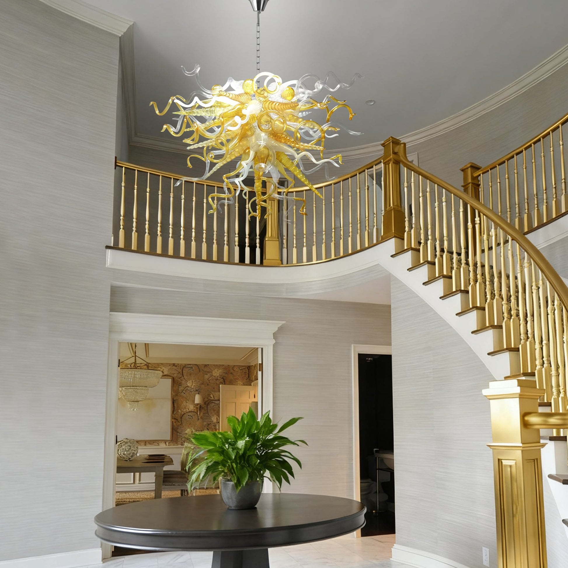 Chihuly style hand blown murano glass chandelier in a luxury foyer with gold railings.