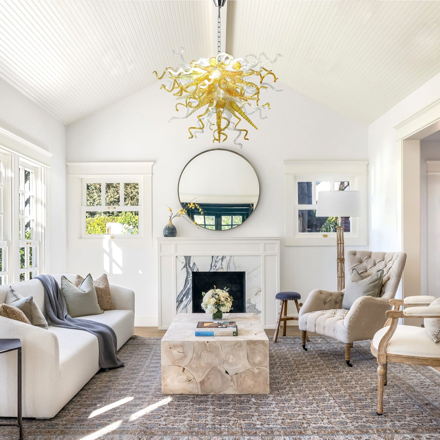 Amber and clear abstract blown murano glass chandelier in a white farmhouse living room.