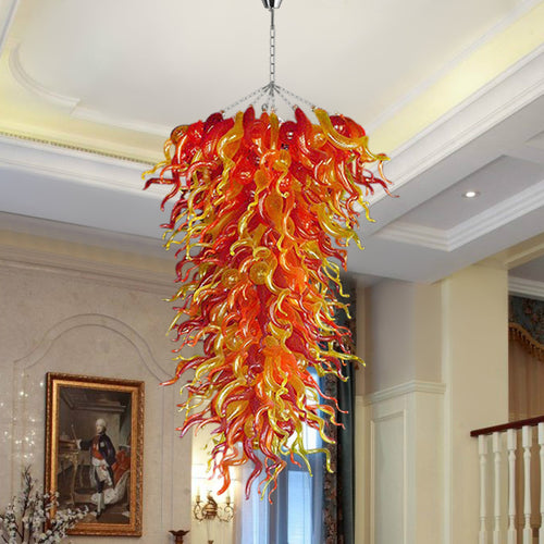 Close-up of the red, orange, and yellow cascading hand blown glass chandelier in a formal living or dining room setting.