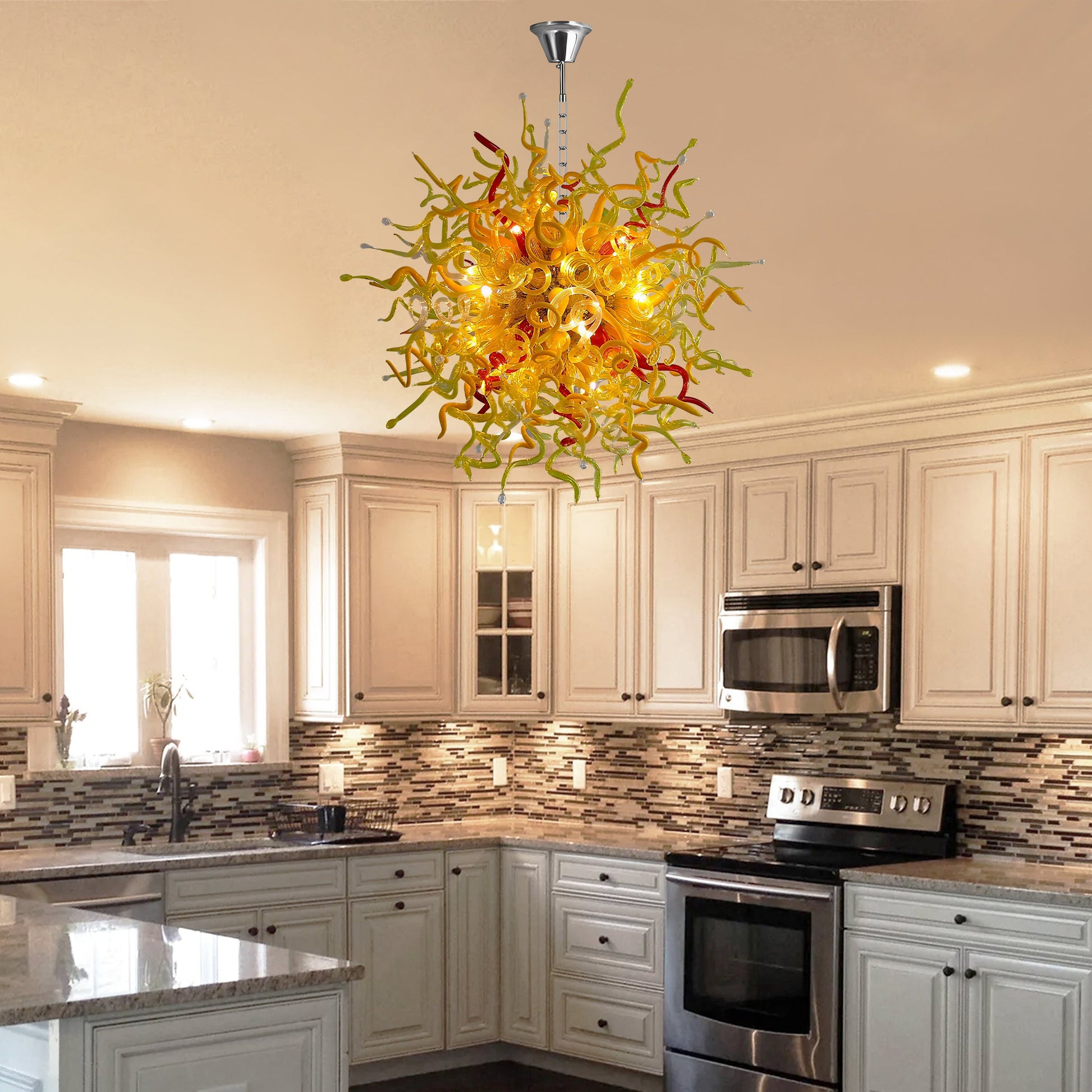 Vibrant yellow and red Chihuly-inspired blown murano glass chandelier above a kitchen island.