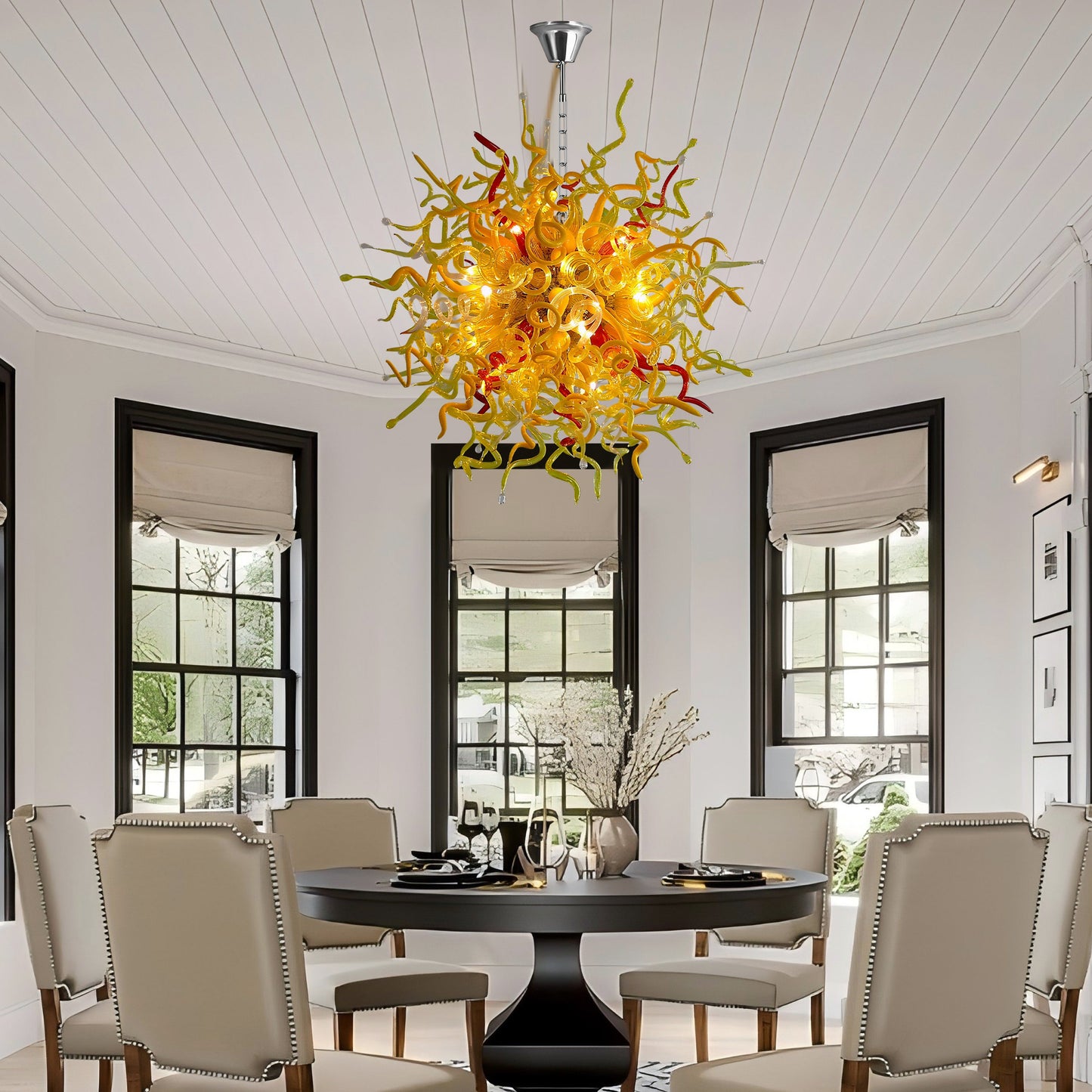 Chihuly-style blown murano glass chandelier installed in a sunlit dining room.