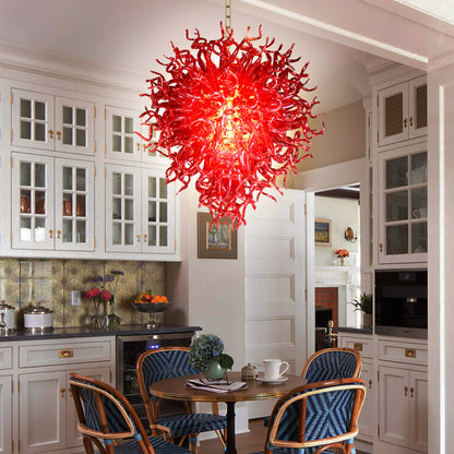 Daring ruby red hand blown glass chandelier as a vibrant focal point in a charming, white traditional kitchen.