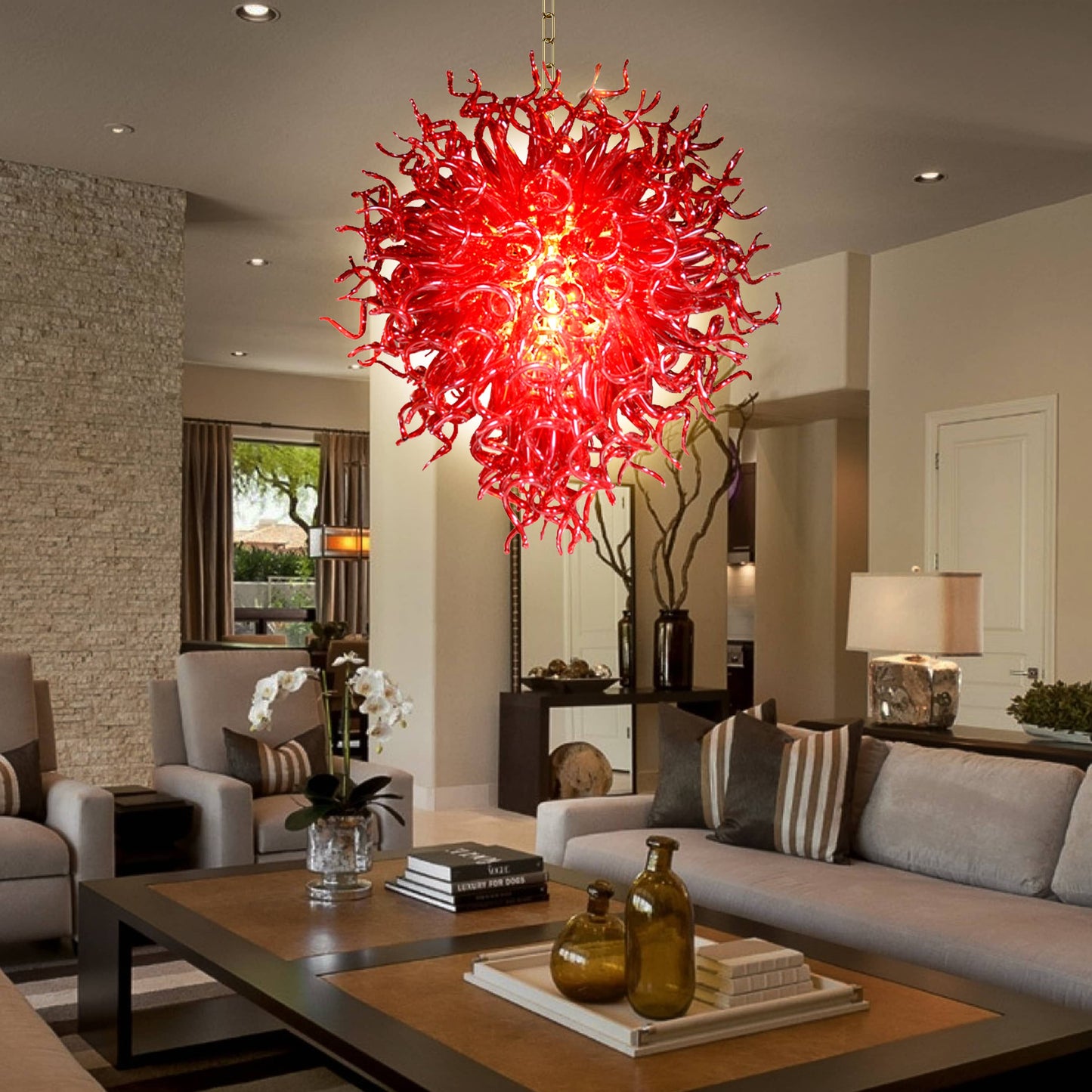Daring ruby red hand blown glass chandelier  in a sleek living room with dark countertops.