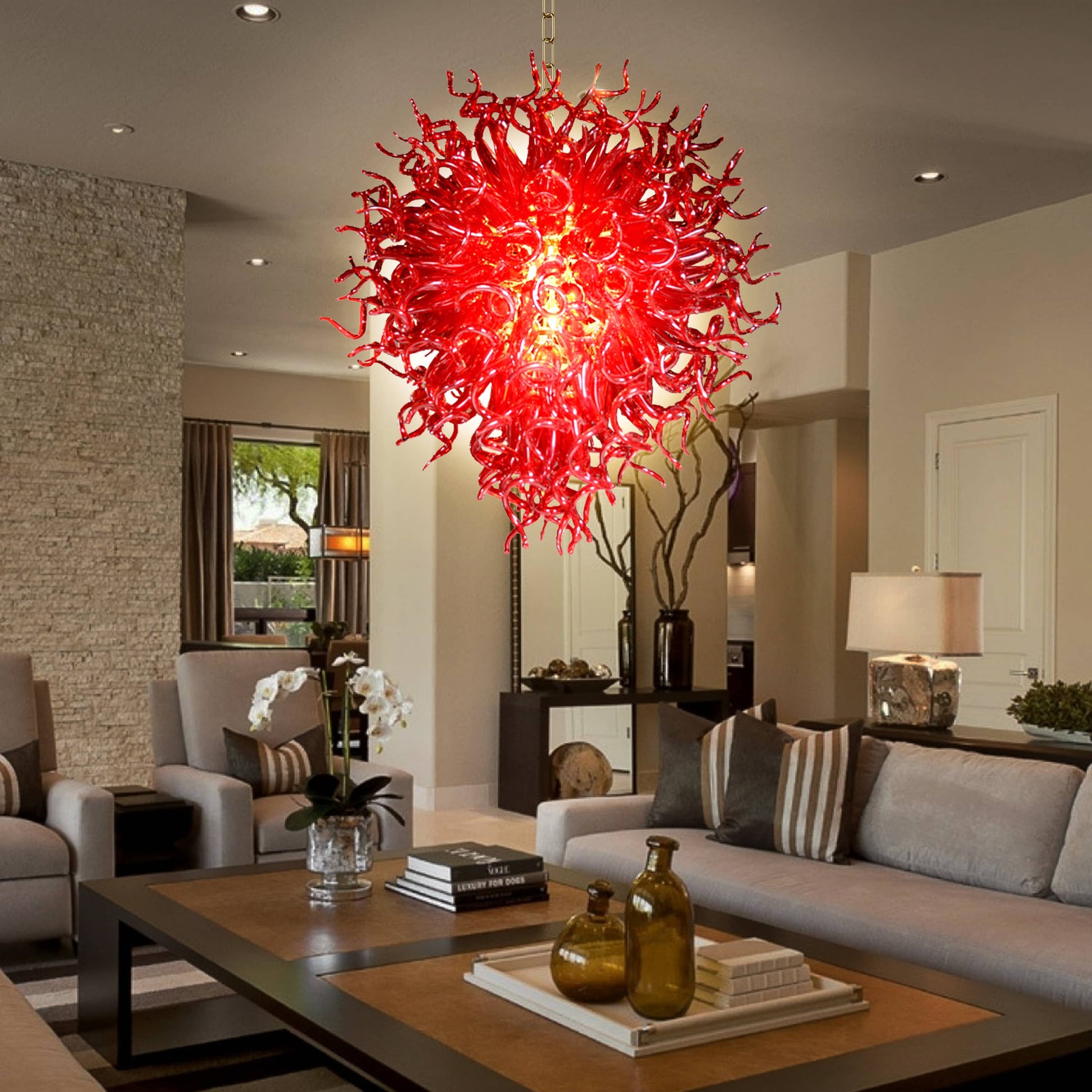Daring ruby red hand blown glass chandelier  in a sleek living room with dark countertops.