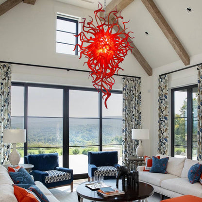 Vibrant red hand blown art glass chandelier in bright sunlit room with mountain views.