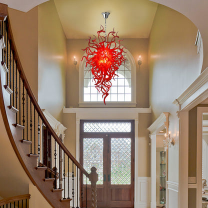 Red Chihuly-style hand blown glass chandelier illuminating a grand entryway.