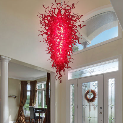 Artistic red murano blown glass chandelier illuminating a grand foyer.