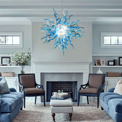 Living room with a blue and white blown glass chandelier, gray sofa, and brown chairs.