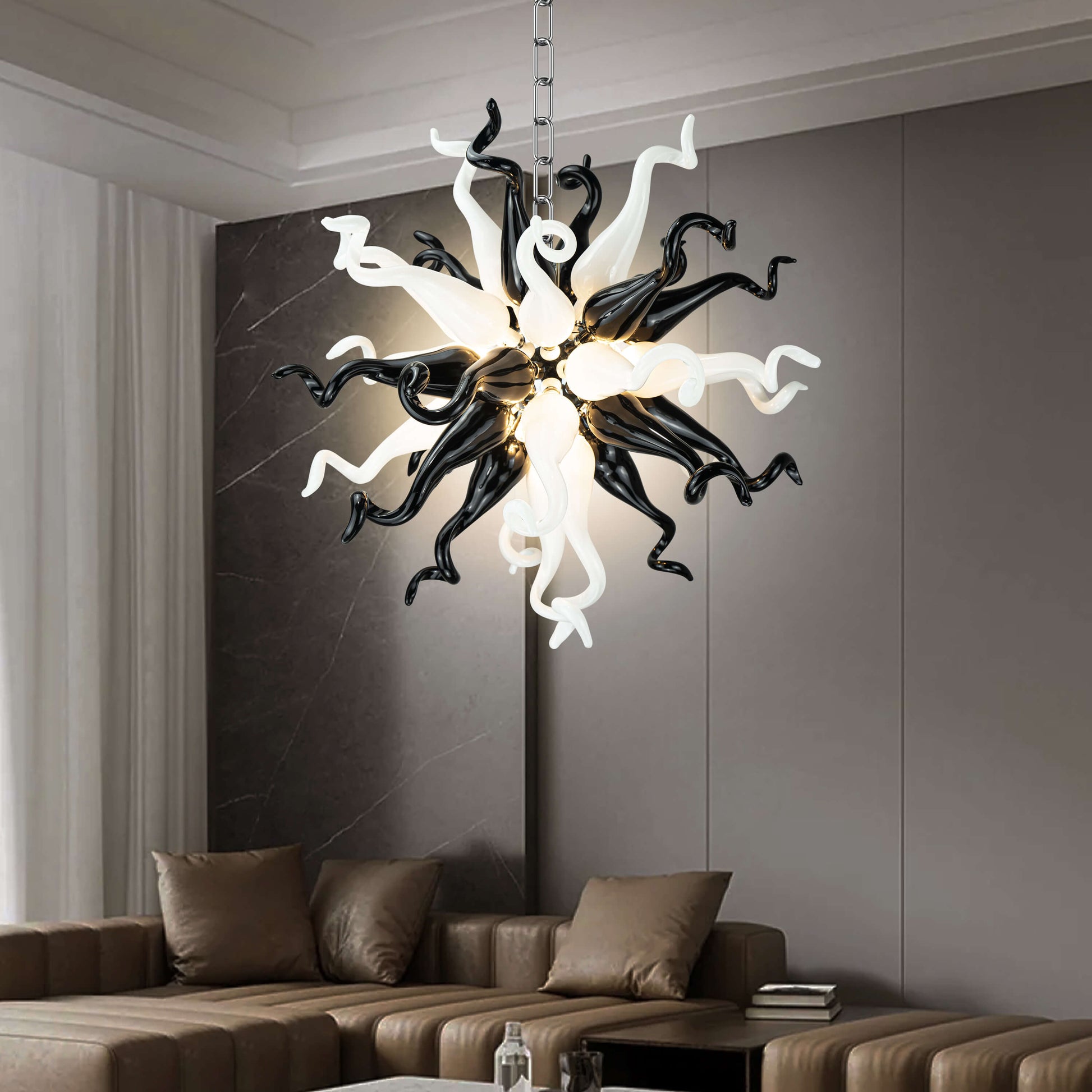 Modern Style Blown Glass Chandelier Black & White Burst hanging in a living room with a brown sofa and gray walls.