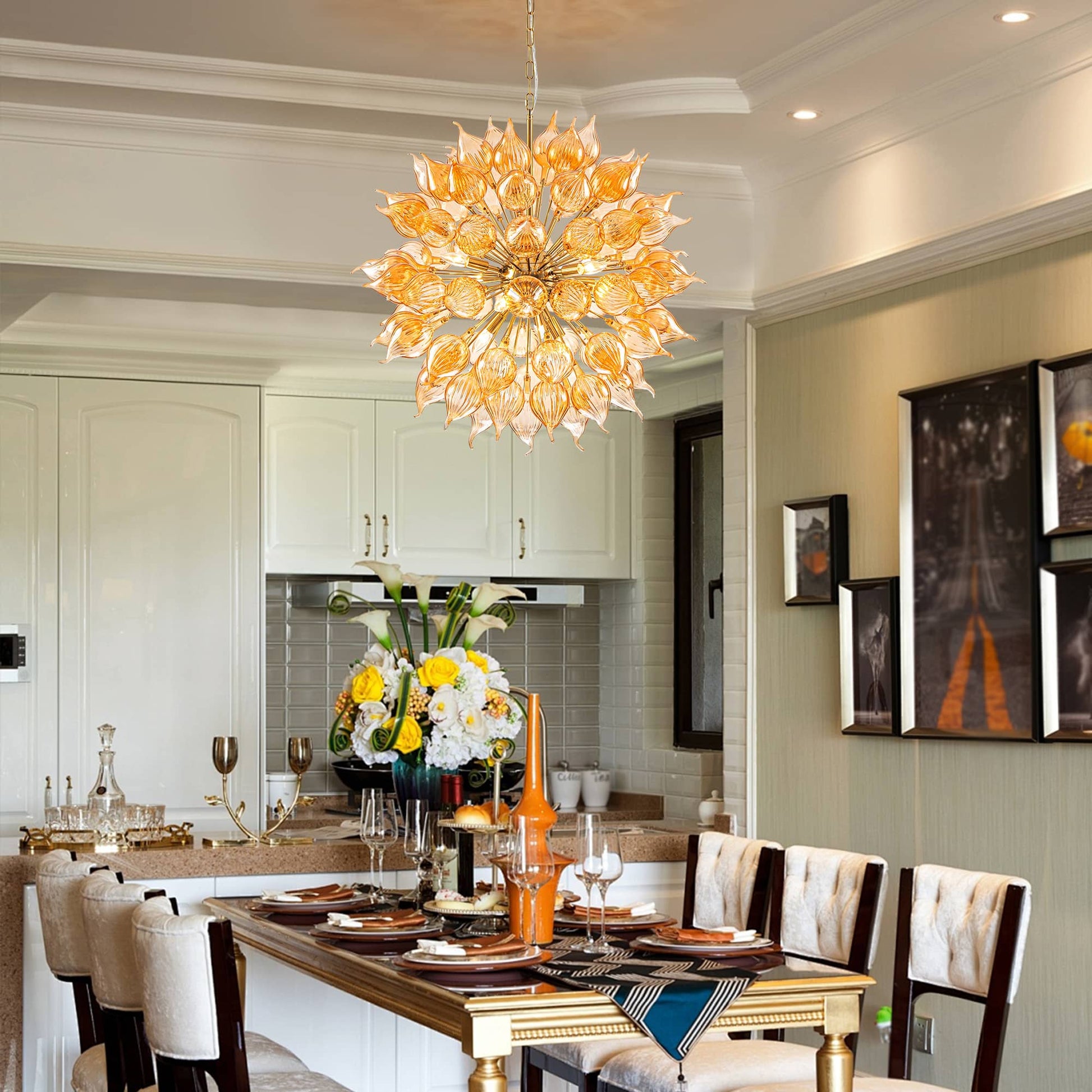 Dining room with a large floral chandelier, table set for dinner, and kitchen in the background.