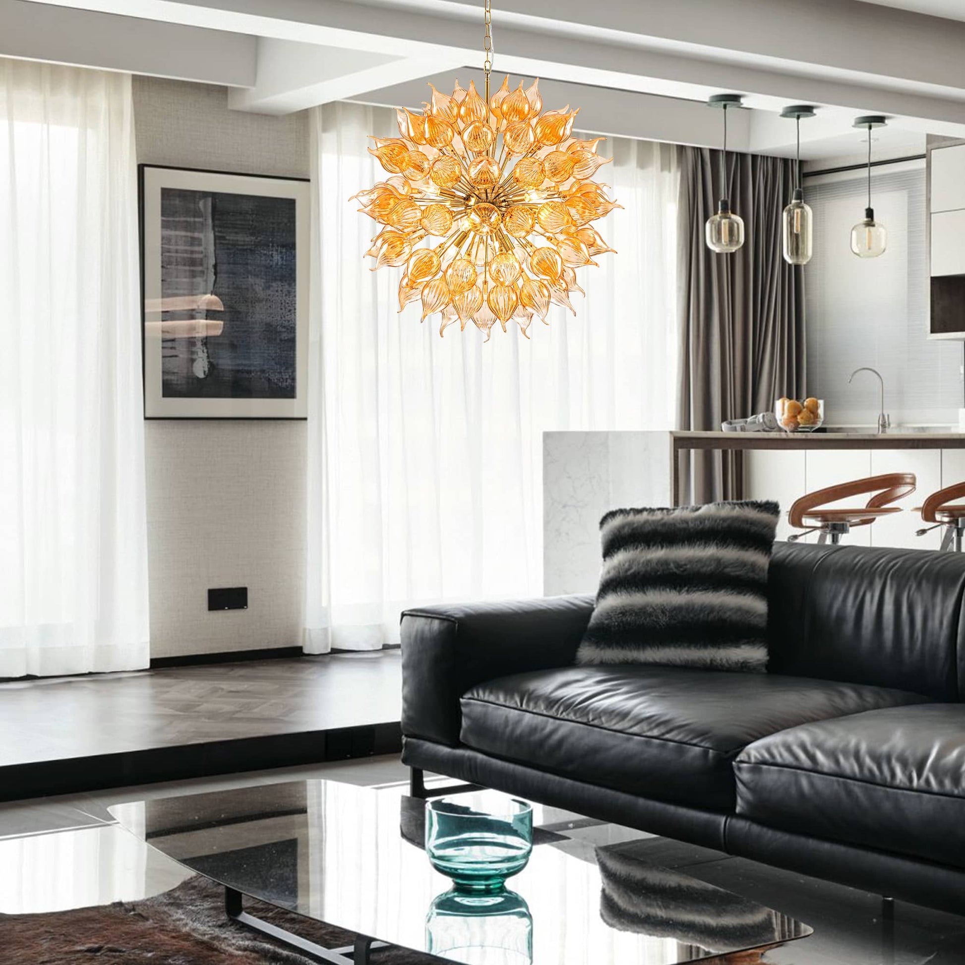 Modern living room with a black leather sofa, decorative pillow, and a sputnik blown glass chandelier.