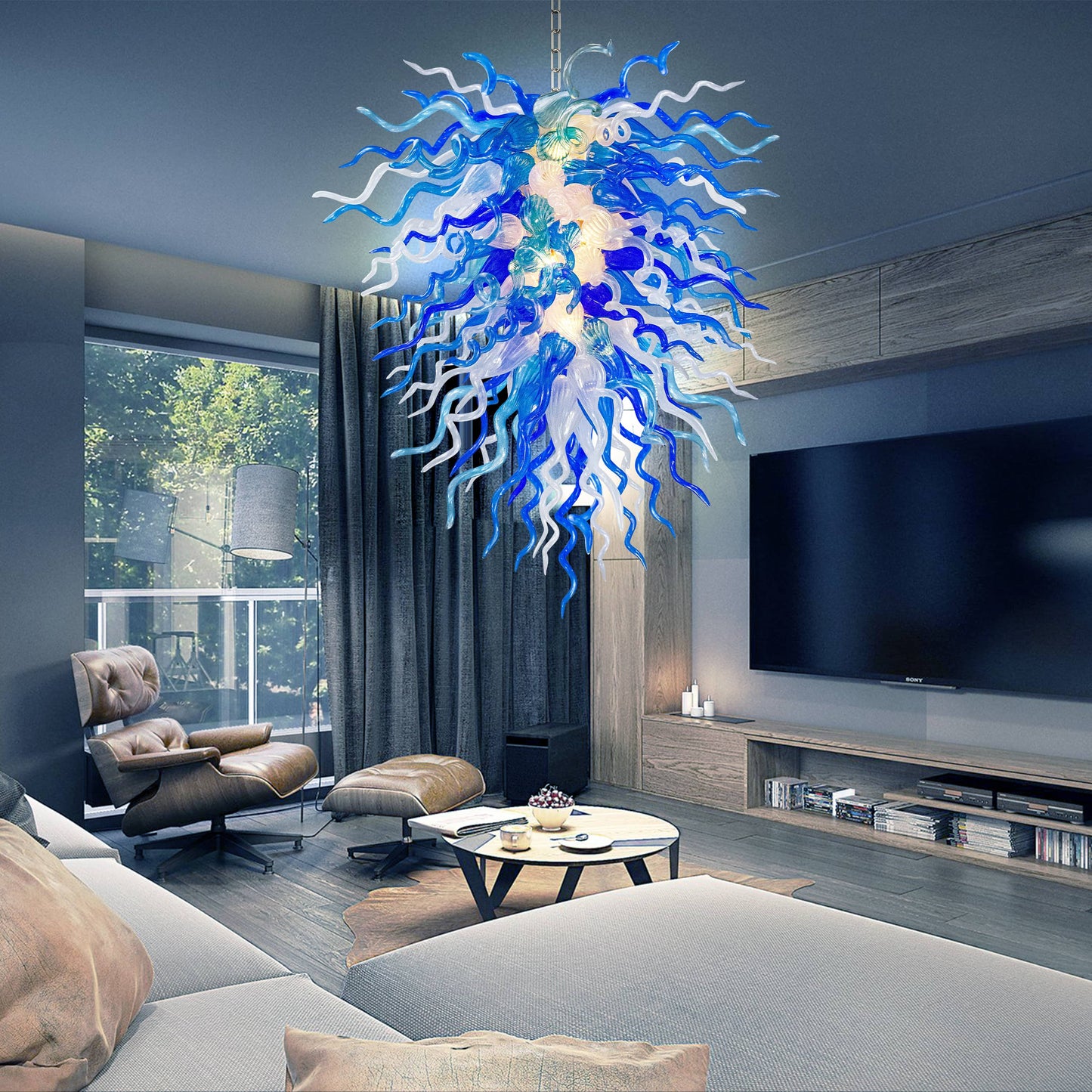 Modern living room with a large blue and white Chihuly chandelier, sofa, coffee table, and TV.