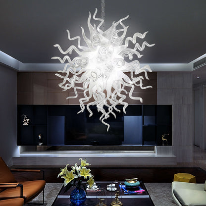 Modern white blown glass chandelier hanging in a living room with a dark wall and furniture.