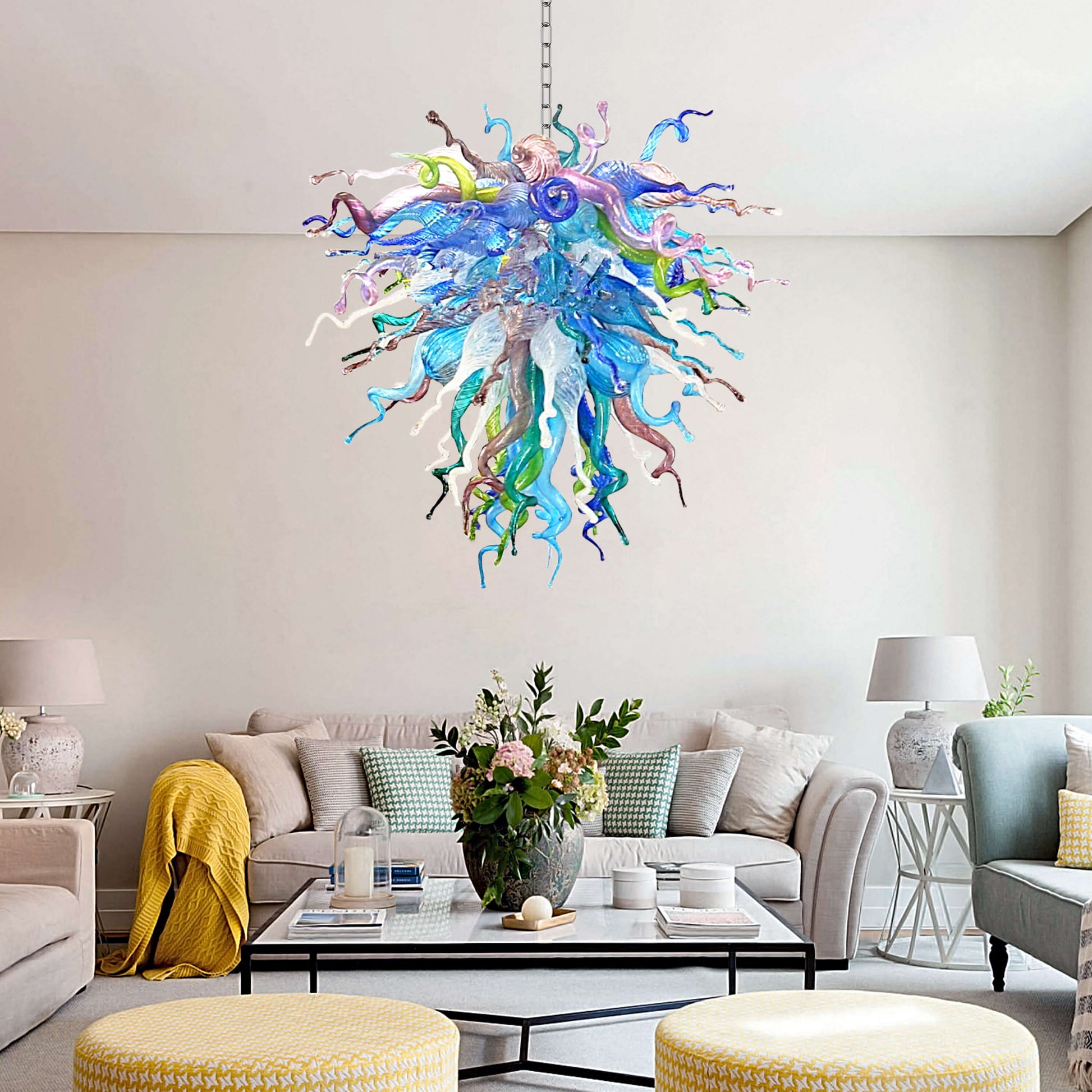 Colorful Chihuly like chandelier hanging above a living room with a sofa and coffee table.